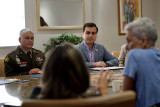 Resident Commissioner seated in table with military office and constituents
